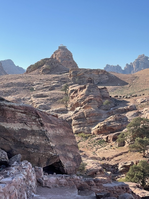 Rocky desert landscape with hills in the background.