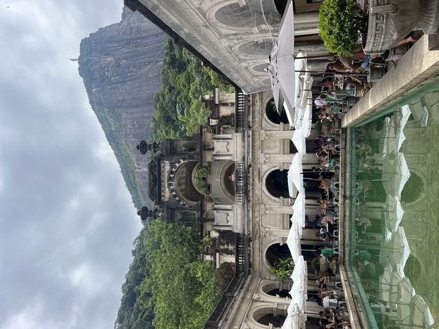 Large building with a pool and crowd.