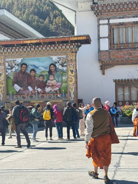 Group of people in front of a decorative mural and architecture.