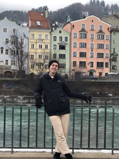 Tourist in front of colorful riverside buildings.