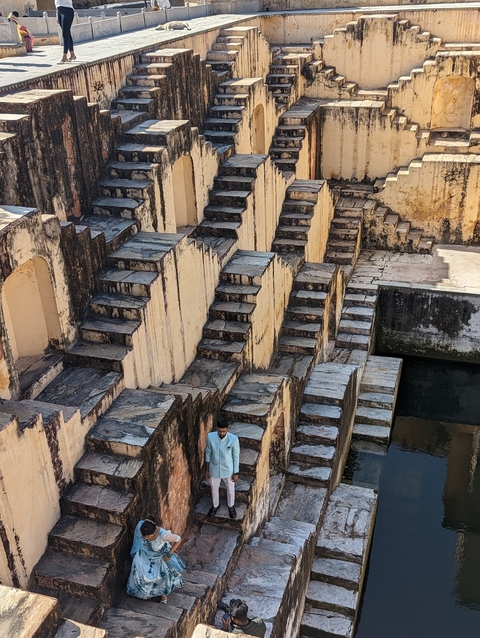Person standing near historic stepwell structure.