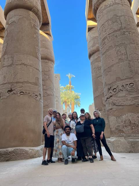       Group of people in front of ancient pillars.
  