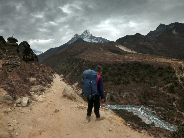 A hiker with a backpack on a mountain path.