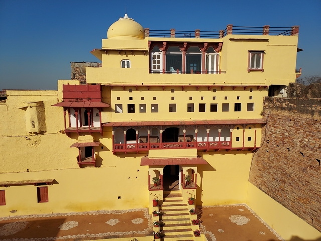       Facade of a yellow and red building with intricate balconies and windows.
  