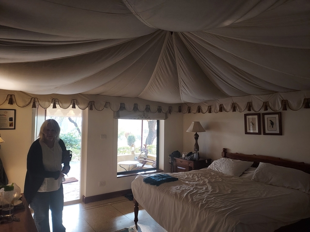       Interior of a tent-like hotel room with a person standing.
  
