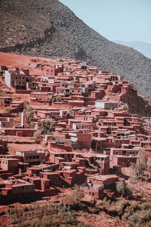 Clustered red clay buildings on a hillside.