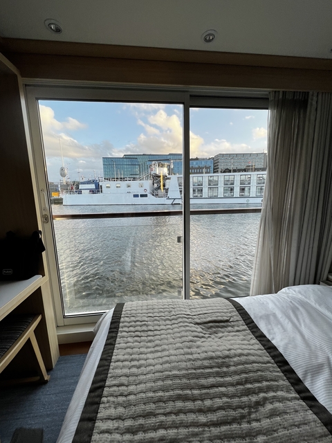 View from inside a cruise cabin overlooking the water.