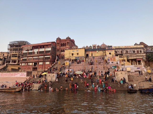 A bustling riverside scene with people and architecture.