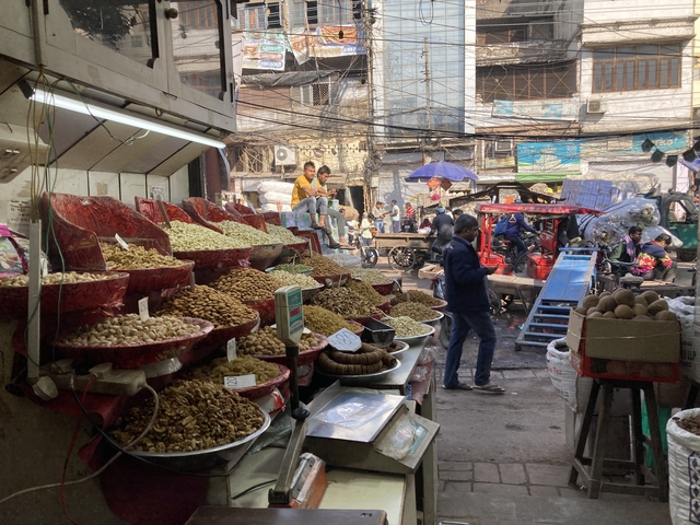 A busy street market with various nuts on display.