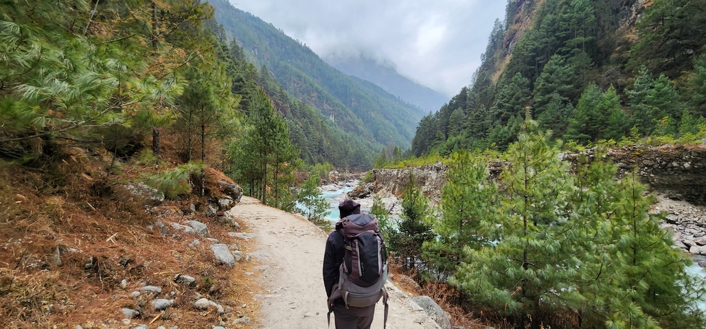 A person trekking along a scenic mountainous path.