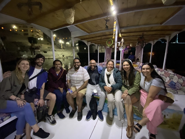 Group of people sitting on a boat at night.