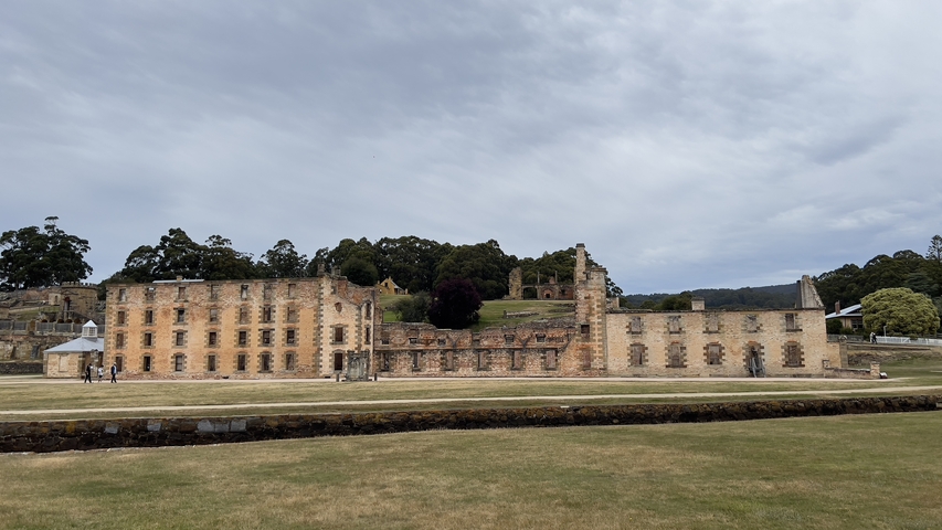 Historic building ruins with people walking around.