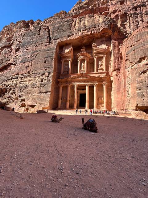 Rock-carved facade in a desert setting.