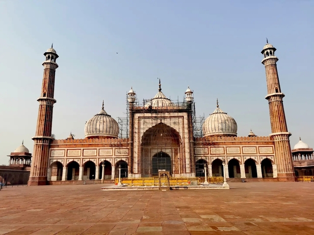 A historical mosque under renovation with scaffolding.