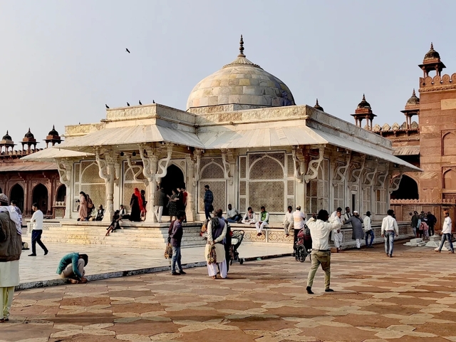 People visiting a historical site with ornate architecture.