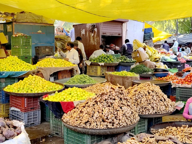 Market scene with various fruits and vegetables on display.