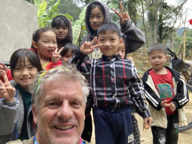 Smiling group of children posing with an adult.