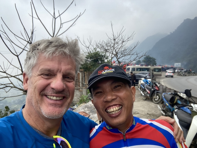       Two people taking a selfie on a mountain road.
  
