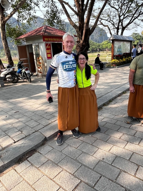       Two people wearing traditional skirts posing for a photo.
  