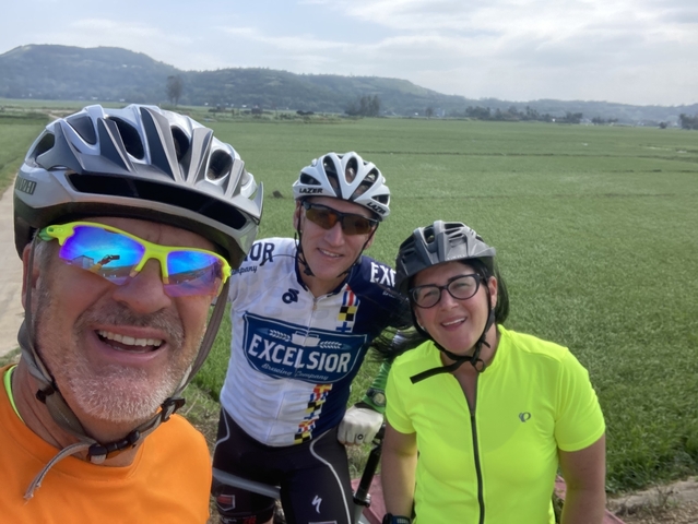       Cyclists taking a selfie in a field.
  