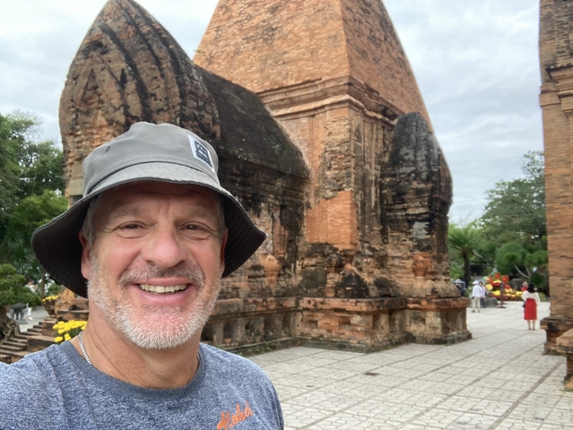 Person taking a selfie with ancient stone structure.
