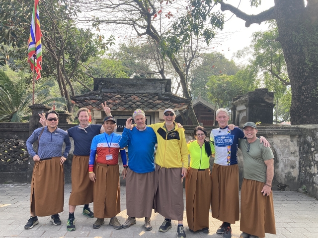       Group of people posing in front of an ancient structure.
  