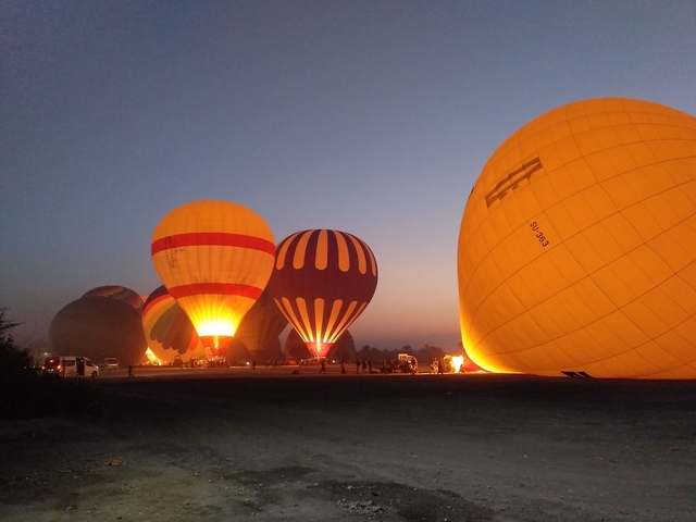 Hot air balloons illuminated at night.
