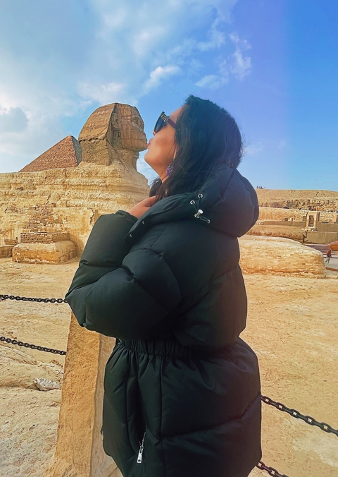       Woman posing with the Sphinx.
  