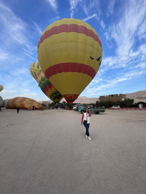       Person walking near hot air balloons on a clear day.
  