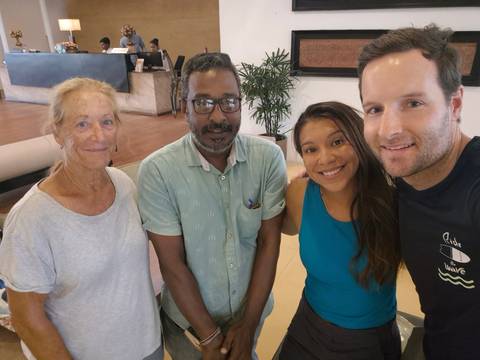 People posing indoors in a tropical setting.