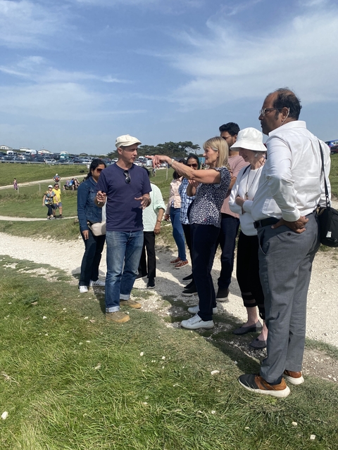 Group of people walking on a trail with one person pointing.