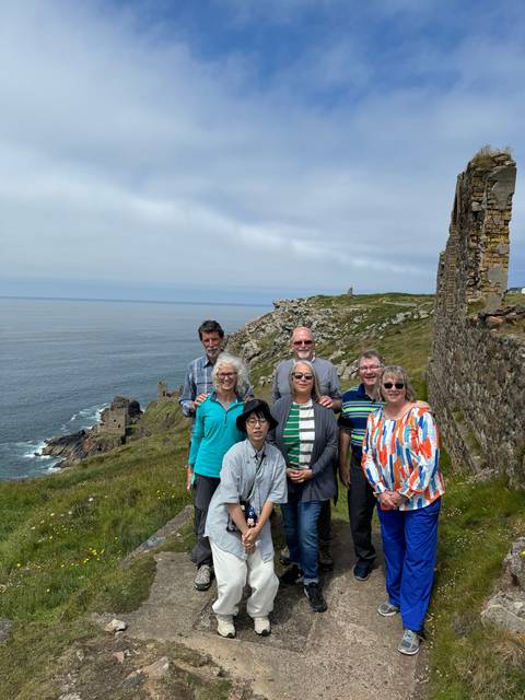 Group photo with coastal cliffs in the background.