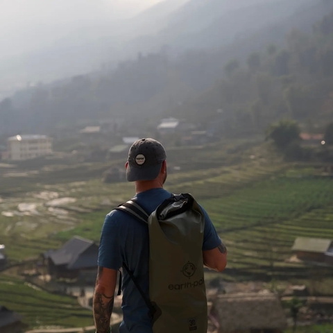       Person with a backpack looking at terraced fields.
  