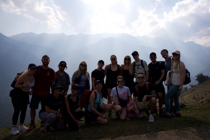       Group of people posing with mountain background.
  