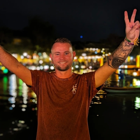       Person smiling with a colorful night backdrop.
  