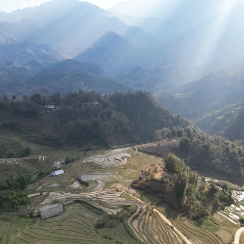       Scenic view of terraced fields with sun rays.
  