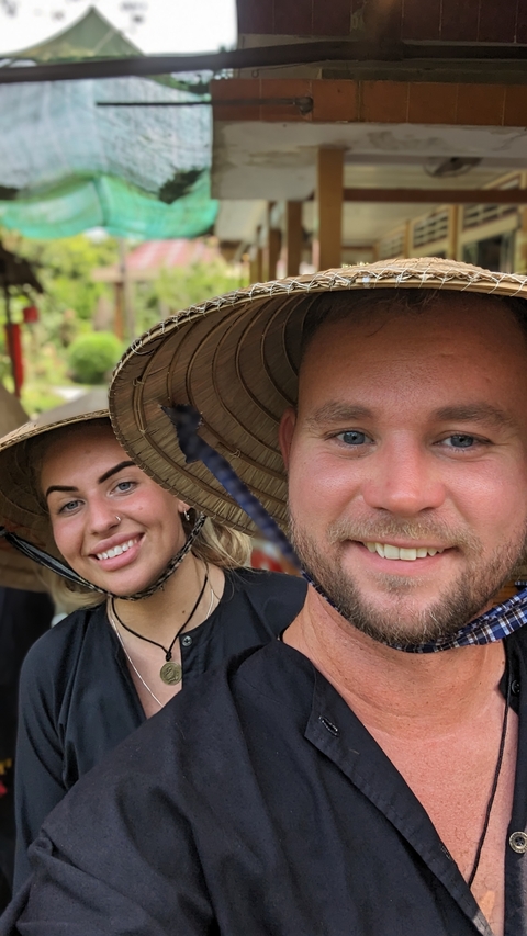 Close-up portrait of a smiling couple wearing traditional hats.