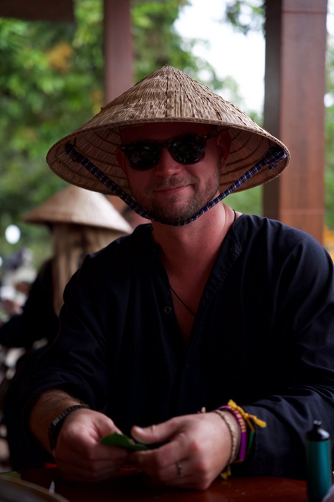 Person smiling while wearing a conical hat.