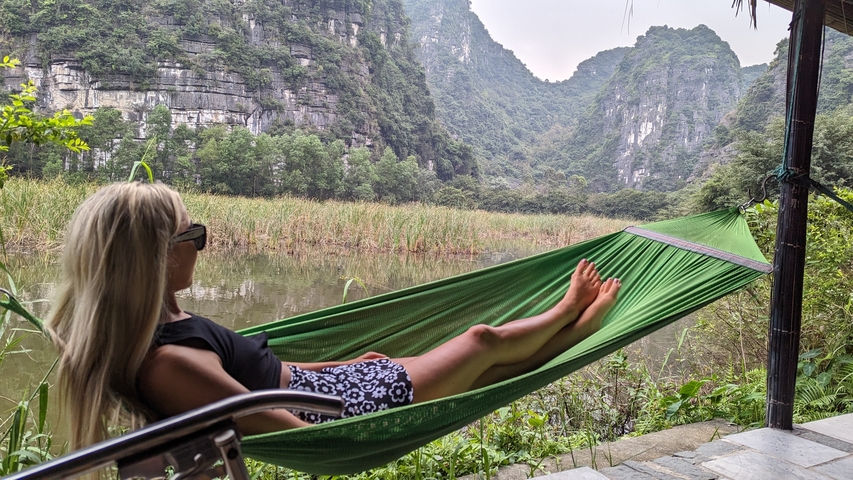      Person relaxing in a hammock with a mountain view.
  