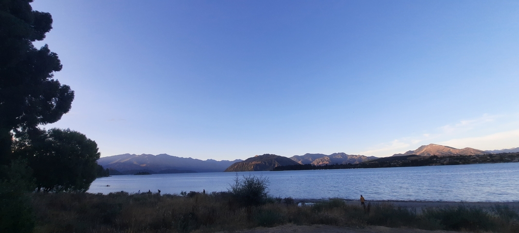 Calm lake with mountains in the background during sunset.