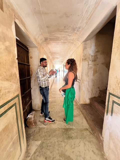 Two people talking in a historic corridor.