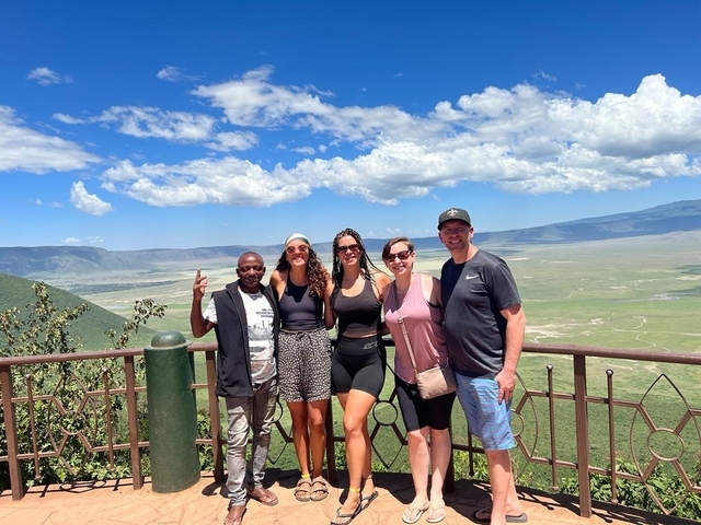 Group of people posing with a scenic landscape in the background.