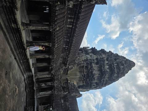 Woman posing at an iconic temple structure in Angkor Wat.