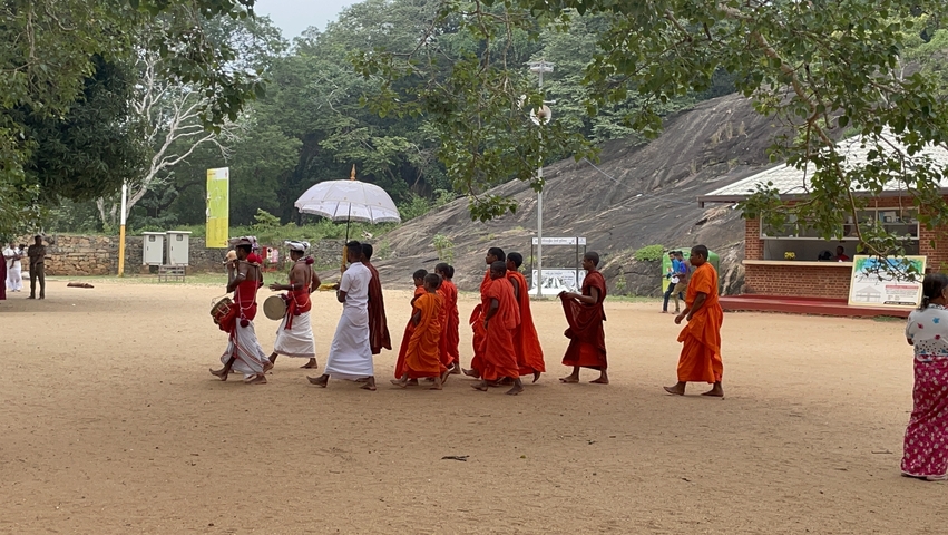 Group of people in traditional attire walking.