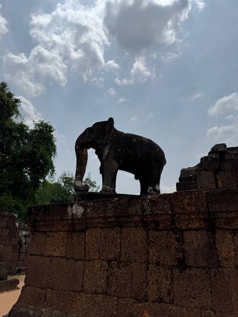 Silhouette of an elephant statue against a sky.