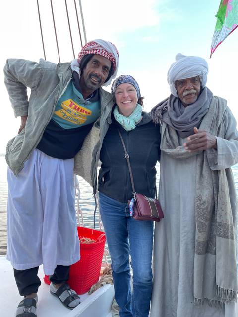 Tourists posing with locals on a boat.