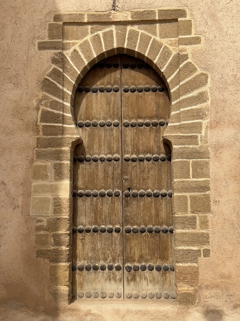 Rustic wooden door framed by stone walls.