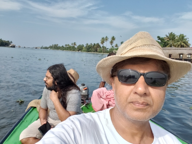 Person in a boat on a river with palm trees.