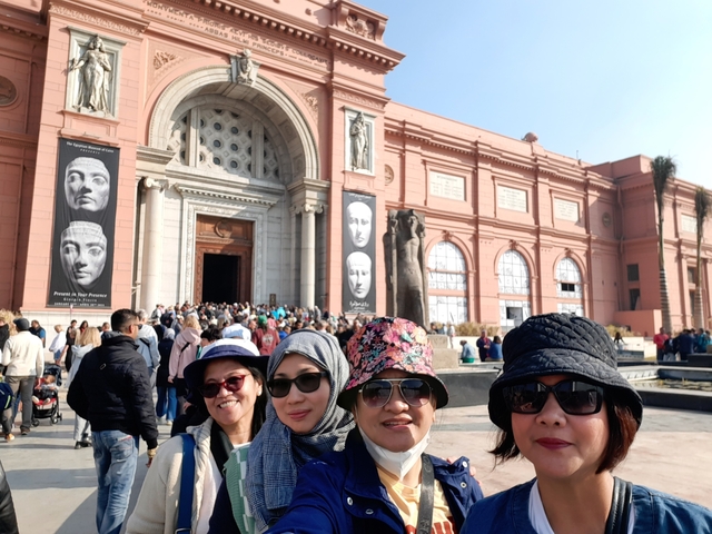 People standing outside a large museum entrance.
