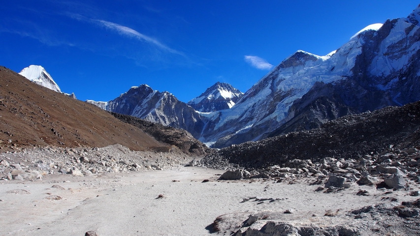       Open valley with rugged terrain and high snow-capped mountains.
  